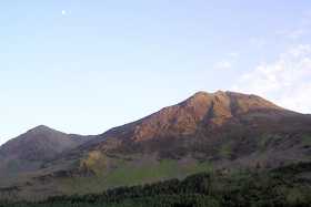 The moon stands out against a blue evening sky above High Crag and High Stile