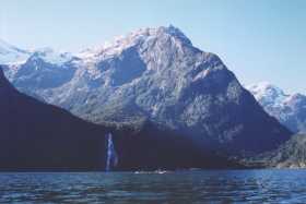 Sea-kayaking on Milford Sound with Bowen Falls in the distance