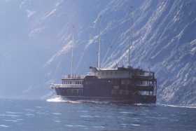 The massive mountains around the sound dwarf the tourist boats